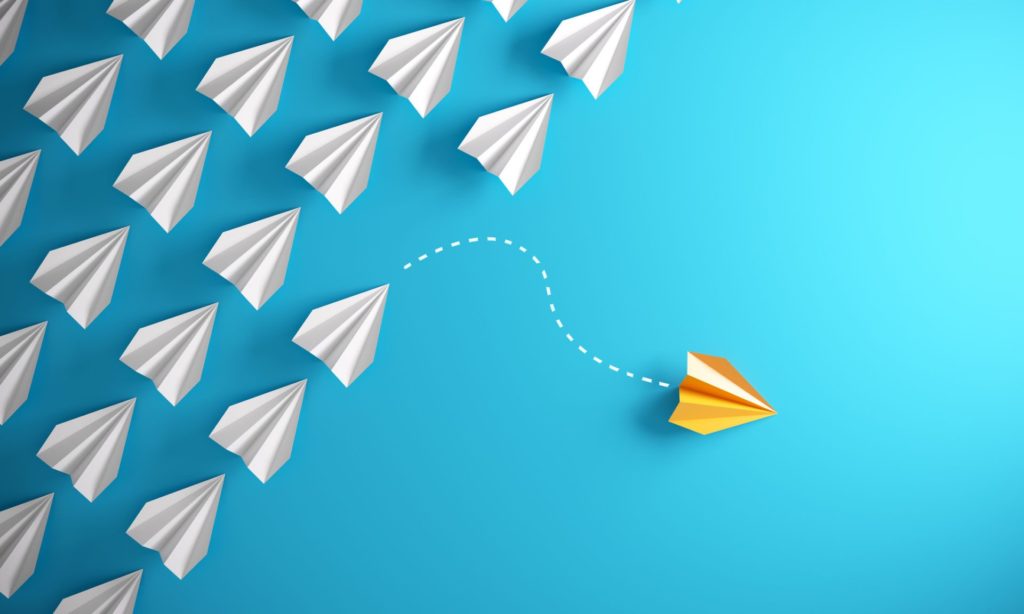 Group of paper plane in one direction and with one individual pointing in the different way, can be used leadership/individuality concepts.( 3d render )